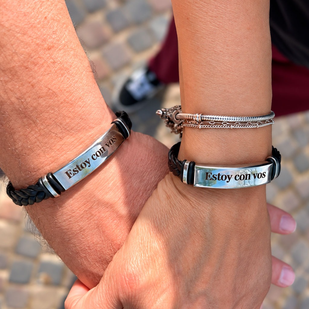 Dos personas tomadas de la mano usando las pulseras Estoy con vos